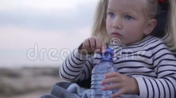 小女孩在夏天的公园里用塑料瓶喝水视频的预览图