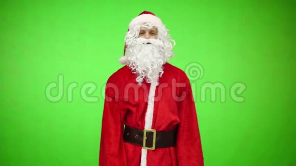 传统的圣诞老人站在绿色的背景上系着腰带视频的预览图