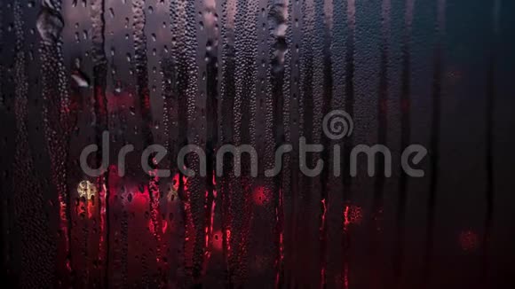 随着城市灯光模糊的背景雨季玻璃窗户上的雨滴被关闭概念视频的预览图