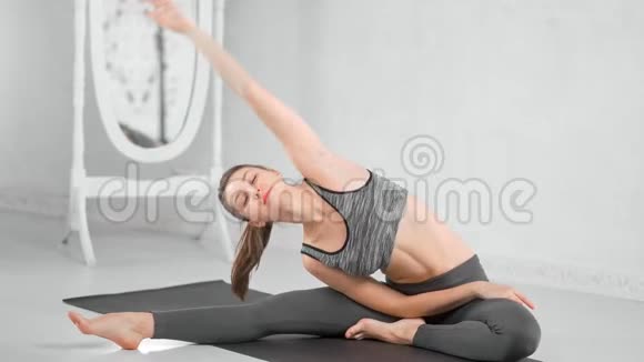 活动健身弹性年轻女性完美的身体享受在家垫子上伸展视频的预览图