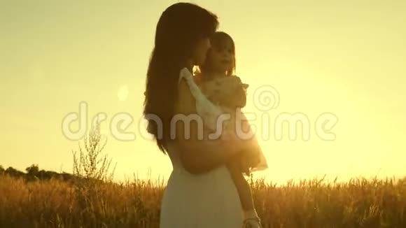 妈妈和小女儿正在阳光下的一片成熟的麦子上玩耍母亲带着孩子走在麦地里视频的预览图