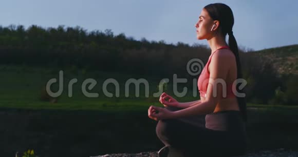 在美丽的风景中一位做瑜伽练习的神奇女士在大自然中摆出冥想姿势她感到轻松视频的预览图