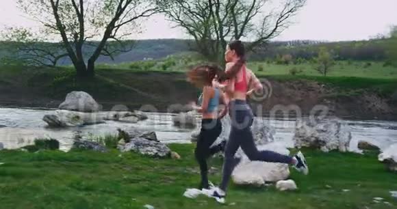 年轻的女士们在一个美好的夏日里经过一段艰苦的跑步锻炼停止了几分钟在早上放松了一下视频的预览图