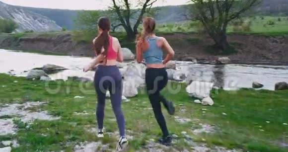 两位体育女运动员在美丽的风景中奋力奔跑她们停下来休息一会儿视频的预览图