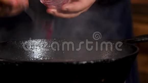 在铁煎锅里煮酱汁的男性手的特写镜头库存录像厨师为这道菜准备美味的沙司视频的预览图