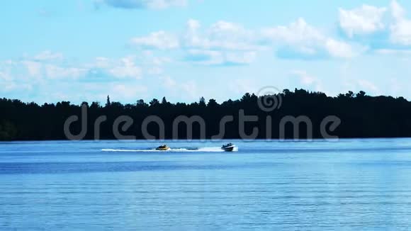 在美丽的明尼苏达湖上划船游乐速度摩托艇将一根娱乐管拉过波浪其中一名乘客摔倒了视频的预览图