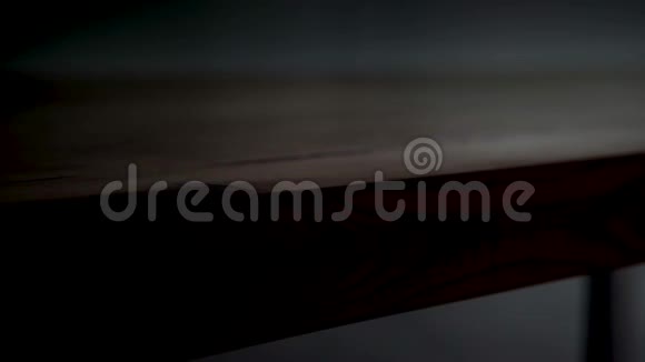 深色背景下木桌边缘的特写库存录像美丽光滑的棕色木桌边被点亮视频的预览图