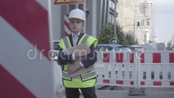 这个小男孩戴着头盔戴着安全帽统一持有建筑计划控制工作建筑师概念工程师视频的预览图