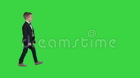 穿着经典深蓝色商务服装的男孩走在绿色屏幕上Chroma键视频的预览图