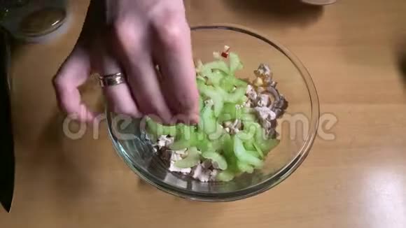 女孩撒盐放酸奶油混合鸡肉芹菜和苹果沙拉视频的预览图