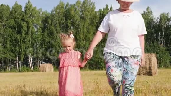 祖母和孙女在草地上散步视频的预览图