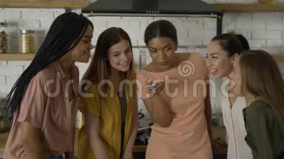 厨房里的5个女朋友正在听手机上的语音信息4K视频的预览图