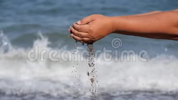 海上休息手中的一个小贝壳在汹涌的海浪的背景下掉落下来贝壳瀑布视频的预览图
