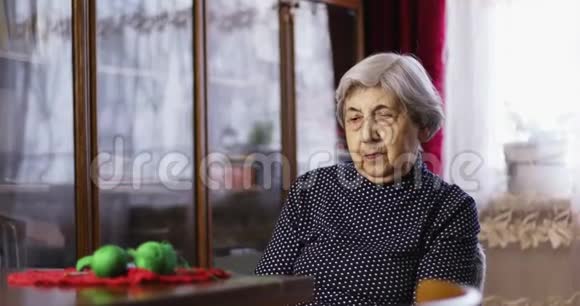 一位头发灰白的祖母坐着说话视频的预览图