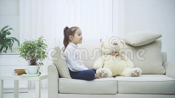 两个漂亮的女孩坐在沙发上玩石头剪刀决定谁来玩白色软熊视频的预览图