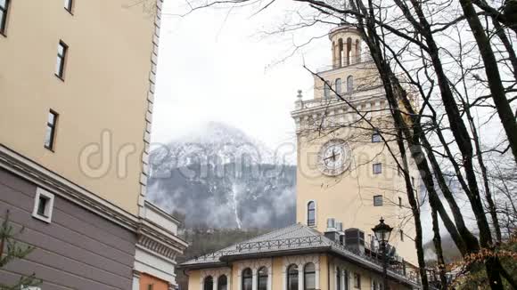 教堂小教堂的钟楼墙上有一个时钟背景是一座雪山库存录像这个视频的预览图