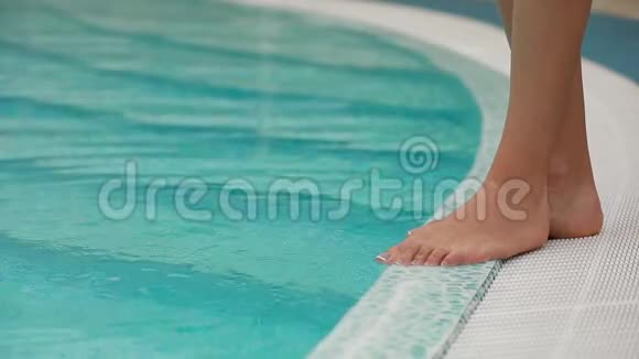 女性腿部测量泳池水温视频的预览图