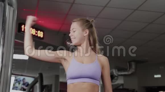 运动女性健美运动员有一个漂亮的身材一个女孩在健身房摆姿势视频的预览图