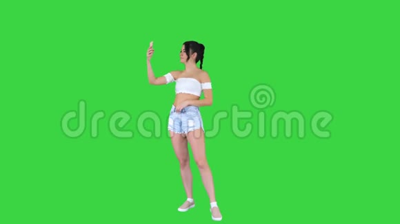 可爱的黑发女孩自拍和跳舞的绿色屏幕Chroma键视频的预览图