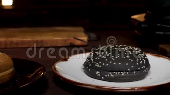 汉堡包在盘子上站在木桌上在黑暗的房间然后烹饪过程库存录像黑白的视频的预览图