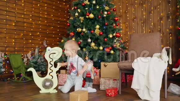 带玩具恐龙的小男孩在圣诞树附近视频的预览图