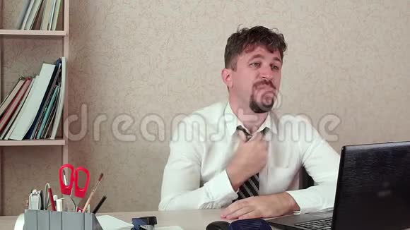 办公室经理胡子男工作热情脱下领带他坐着视频的预览图