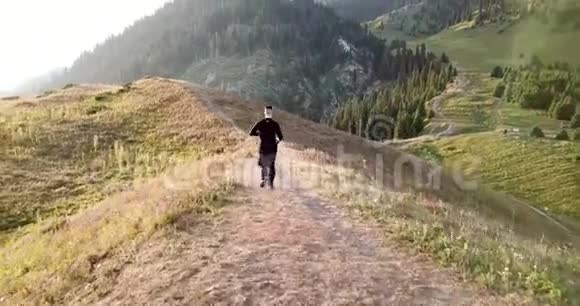早晨在小径上的山上慢跑那家伙跑在一座青山上视频的预览图