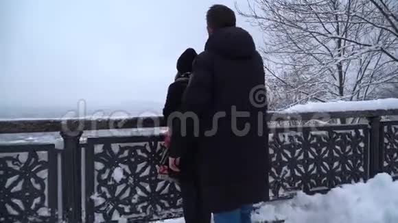 一对年轻夫妇在雪地公园的约会年轻人和漂亮女孩正在户外散步视频的预览图