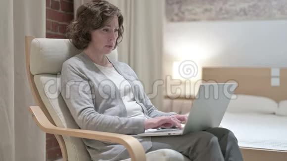 勤劳的老妇人在沙发上有头痛视频的预览图