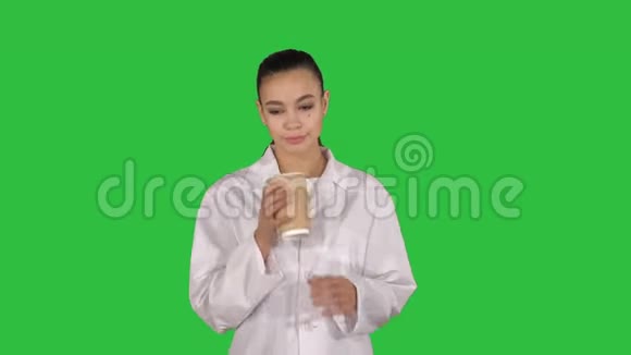 年轻的拉丁医生休息一下在绿色屏幕上喝咖啡Chroma键视频的预览图