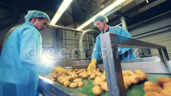 两个男人在一家食品厂工作切干净的土豆视频的预览图