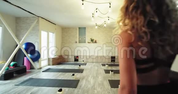 年轻的女士练习瑜伽她来到一个瑜伽工作室用自己的运动垫为她的灵魂冥想视频的预览图