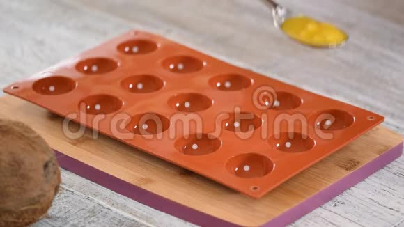 在硅胶模具中展开填充摩丝蛋糕芒果馅的制作过程特写镜头视频的预览图
