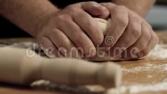 专业面包师揉面团特写库存录像面包师傅的大手在面团上揉面粉视频的预览图