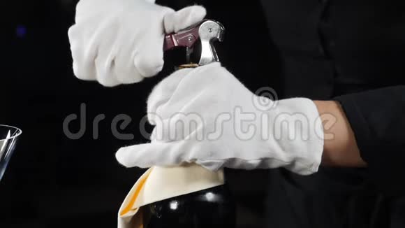 酒庄的概念在餐厅为客人打开一瓶葡萄酒的侍酒特写镜头戴白手套的侍者视频的预览图