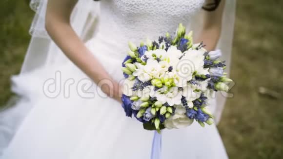 新娘穿着白色连衣裙手里拿着一束婚礼鲜花行动精致的玫瑰花束带着丝带视频的预览图