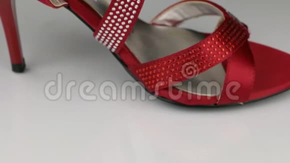 宏观特写缓慢旋转的红色妇女凉鞋的白色背景视频的预览图