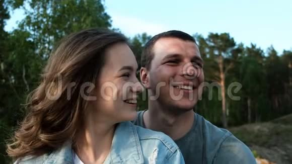 一对幸福的年轻夫妇的慢动作肖像一个迷人的女人微笑着吻她的男朋友视频的预览图
