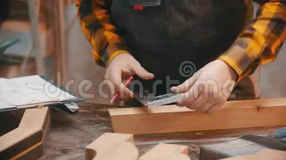 室内木工一个用铅笔和尺在木制细部上做标记的木工视频的预览图