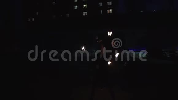 两名竞技者在户外的夜晚令人印象深刻地转动着火球视频的预览图
