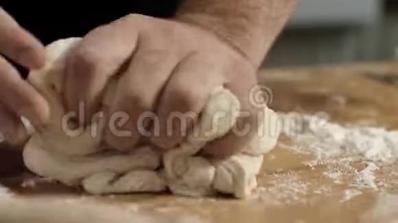 专业面包师揉面团特写库存录像面包师傅的大手在面团上揉面粉视频的预览图