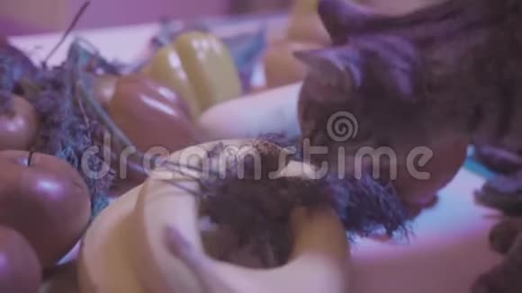 猫吃欧芹库存录像晚上在桌子上吃欧芹的猫特写猫在玩吃蔬菜视频的预览图
