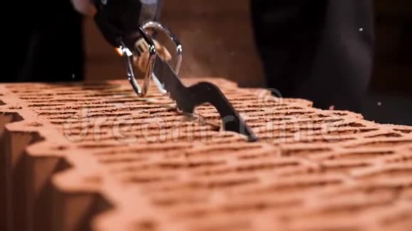 特写镜头一名男子用电锯在一片尘土中锯断一个街区库存录像新砖细节视频的预览图