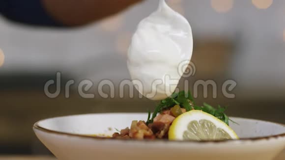 有人用索里扬卡的手在碗里加酸奶油的特写镜头库存录像俄罗斯索里扬卡汤视频的预览图