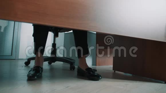 无法辨认的办公室工作人员在桌子下面踩着黑色皮革懒汉的腿视频的预览图