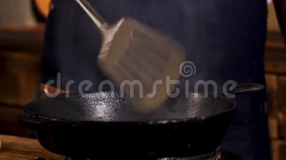用黑色铁锅将男厨炒制的食材合上用金属铲子搅拌库存录像流程视频的预览图