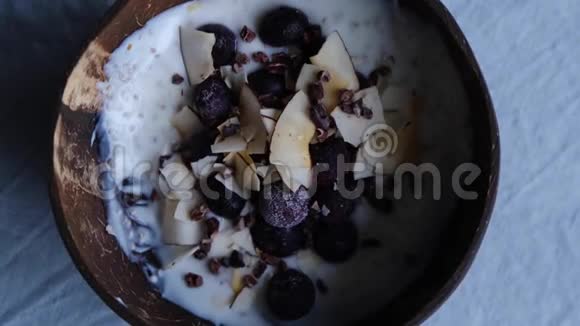 椰子酸奶含辣椒籽椰子片可可和冷冻蓝莓视频的预览图