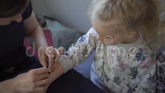 可爱的女孩手臂有临时纹身儿童娱乐服务视频的预览图