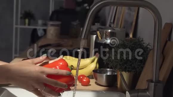 厨师手里拿着一枝新鲜的有机红樱桃番茄在干净的自来水下洗净形成飞溅视频的预览图