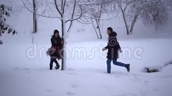 可爱的年轻人和女孩在一个白雪覆盖的公园里度过他们的闲暇时光年轻夫妇的约会恋爱中的幸福夫妻视频的预览图